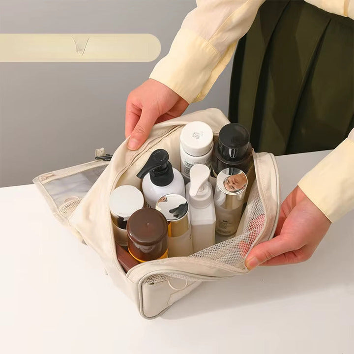 Persona che organizza prodotti per la cura della pelle in una borsa da viaggio beige su un tavolo bianco. Cosmetici, flaconi, routine di bellezza.