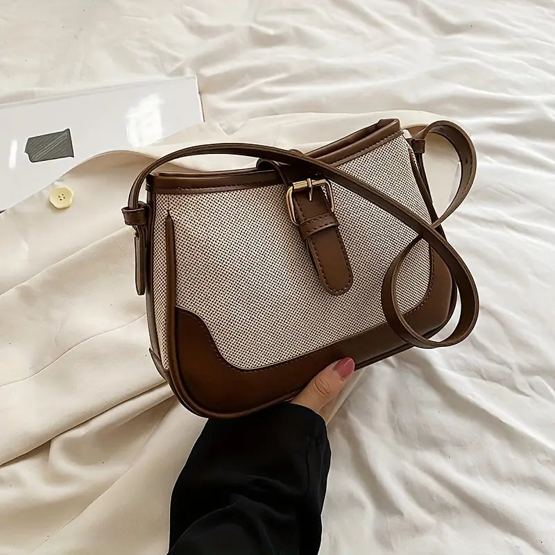 Borsa a tracolla in pelle marrone e tessuto bianco, design elegante, chiusura a fibbia, perfetta per moda donna, accessorio versatile e chic.