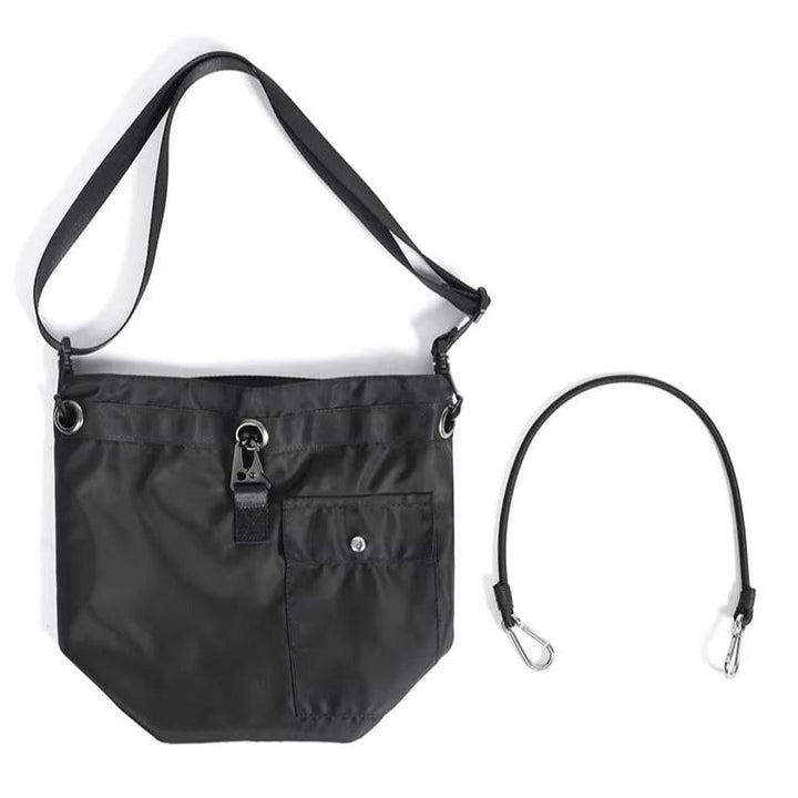 Borsa a tracolla nera in nylon con tasca frontale e chiusura a fibbia, tracolla regolabile e cinturino rimovibile. Accessorio moda unisex.
