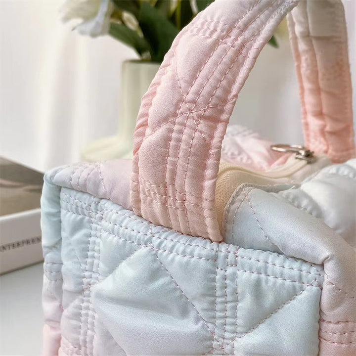 Borsa trapuntata in raso rosa e bianco, manici imbottiti, design elegante. Perfetta per moda femminile, accessorio chic e versatile.