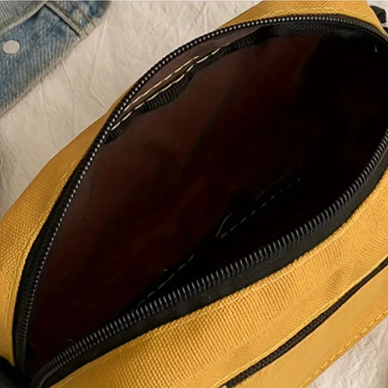 Borsa a tracolla gialla aperta, tessuto resistente, cerniera nera, interno spazioso. Accessorio moda casual, ideale per uso quotidiano.