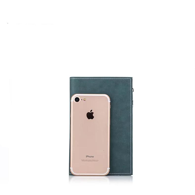 iPhone oro con cover trasparente appoggiato su un taccuino verde. Accessori eleganti, tecnologia e cancelleria di qualità.