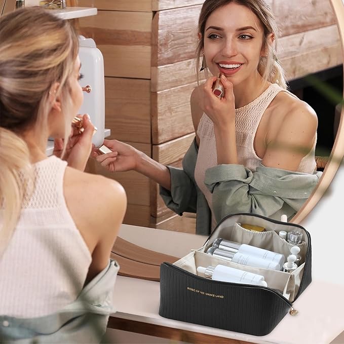 Donna che applica rossetto davanti a uno specchio, con beauty case nero aperto contenente prodotti cosmetici. Routine trucco, bellezza quotidiana.