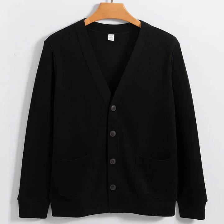 Cardigan nero da uomo in cotone, con scollo a V, bottoni frontali e tasche, appeso su gruccia di legno. Maglione elegante e casual.