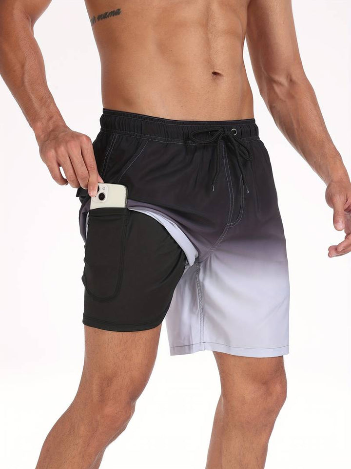 Uomo in costume da bagno sfumato nero e grigio con tasca laterale per smartphone, moda mare, abbigliamento estivo, design funzionale.
