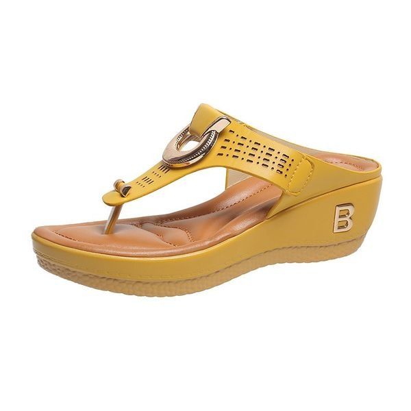 Sandalo donna giallo con zeppa, cinturino decorativo e suola antiscivolo. Calzatura estiva comoda e alla moda. Perfetta per look casual.