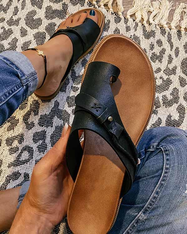 Sandali in pelle nera con fibbia, indossati su tappeto leopardato. Moda estiva, calzature casual donna, comfort e stile.