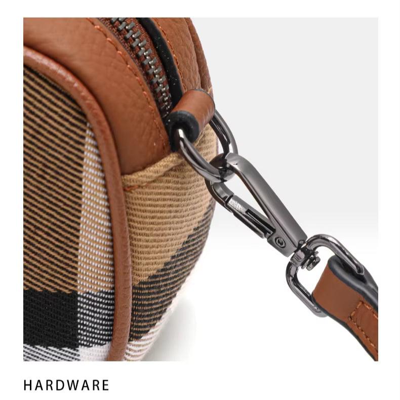 Borsa a tracolla in tessuto a quadri marrone e nero con dettagli in pelle e moschettone in metallo. Accessorio moda elegante e funzionale.