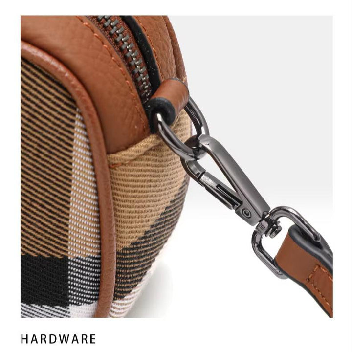 Borsa a tracolla in tessuto a quadri marrone e nero con dettagli in pelle e moschettone in metallo. Accessorio moda elegante e funzionale.
