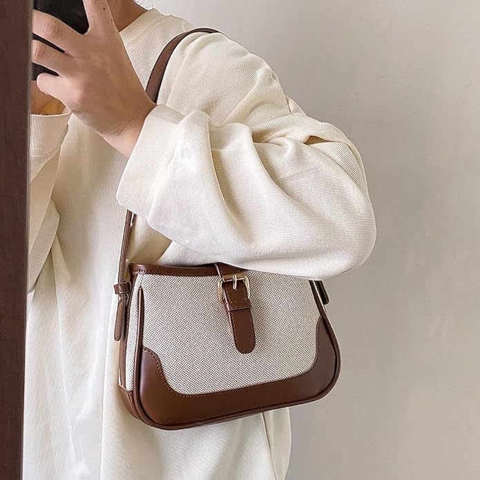 Borsa a tracolla in pelle marrone e tessuto beige, design elegante e moderno, indossata da una persona con maglione bianco. Accessorio moda donna.