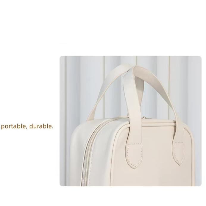 Borsa da viaggio beige in pelle, portatile e resistente, con doppia maniglia. Design elegante, ideale per viaggi e uso quotidiano.
