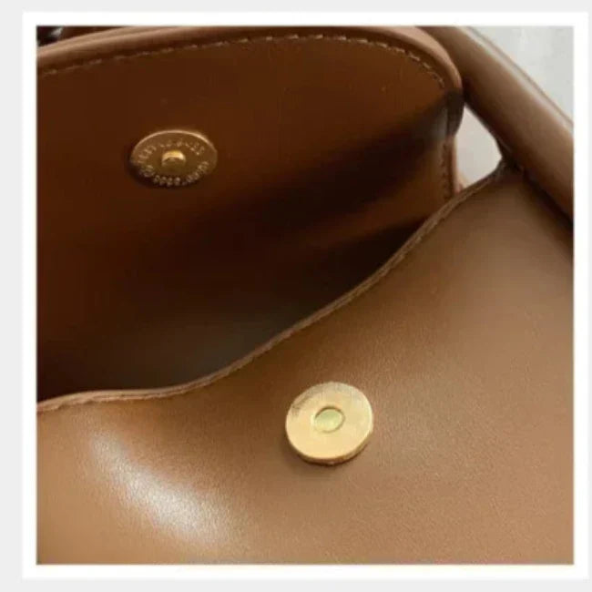 Borsa in pelle marrone con chiusura magnetica dorata, design elegante e moderno, ideale per moda donna, accessorio di lusso.