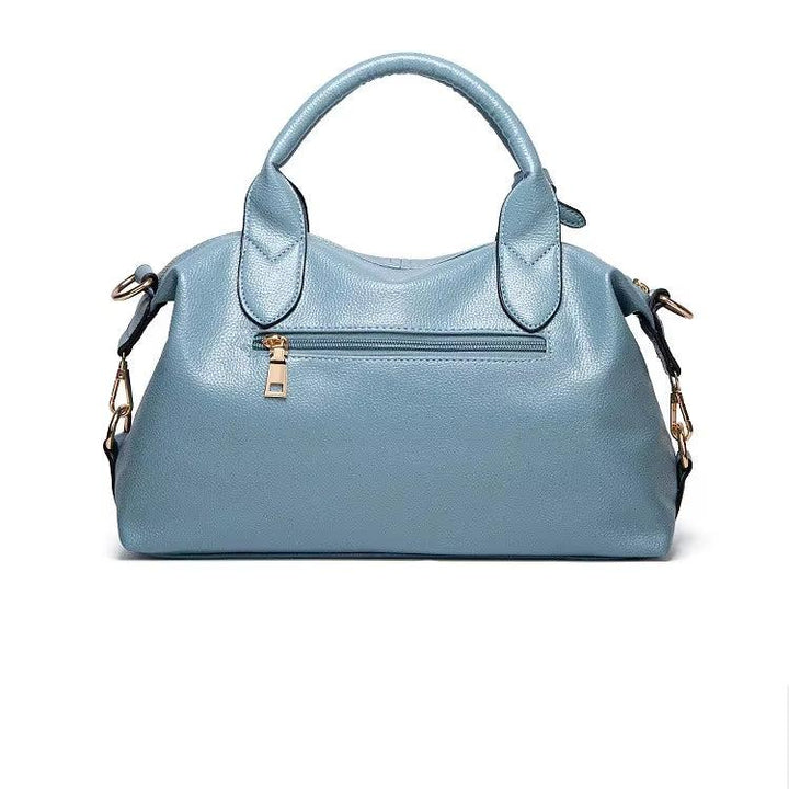 Borsa a mano in pelle blu chiaro, design elegante con tasca frontale con zip, manici robusti e tracolla regolabile. Accessorio moda donna.