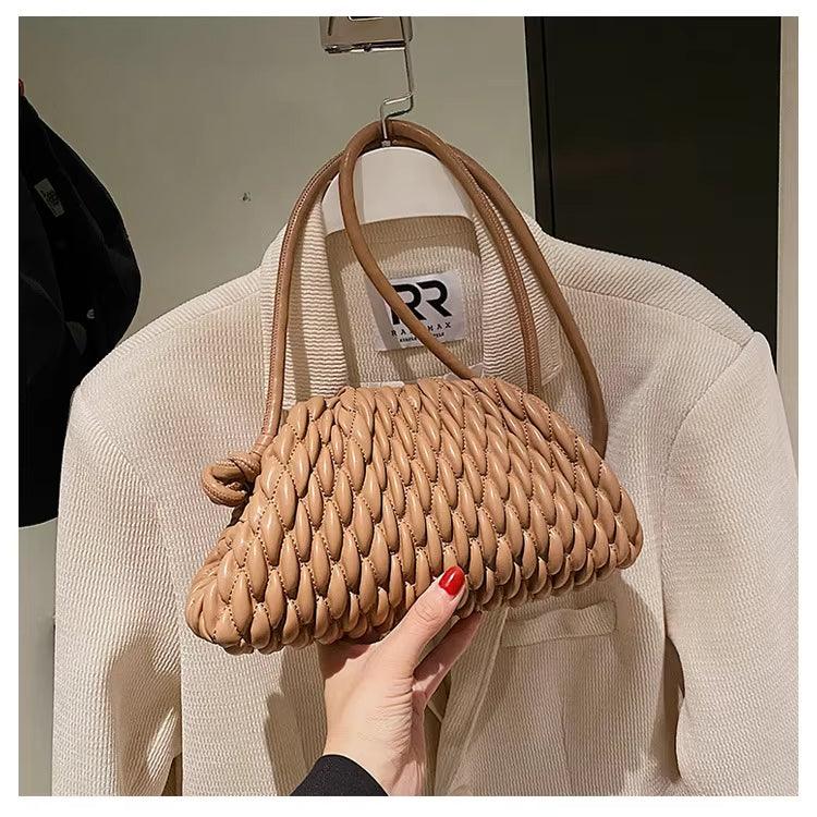 Borsa intrecciata beige su giacca bianca, design elegante e moderno, perfetta per moda donna. Accessorio di tendenza, stile casual chic.