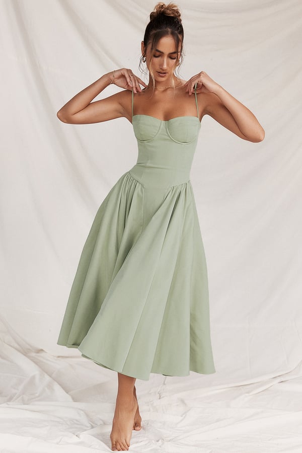Abito midi verde salvia elegante, senza maniche, con scollo a cuore e gonna svasata. Perfetto per eventi estivi e cerimonie.