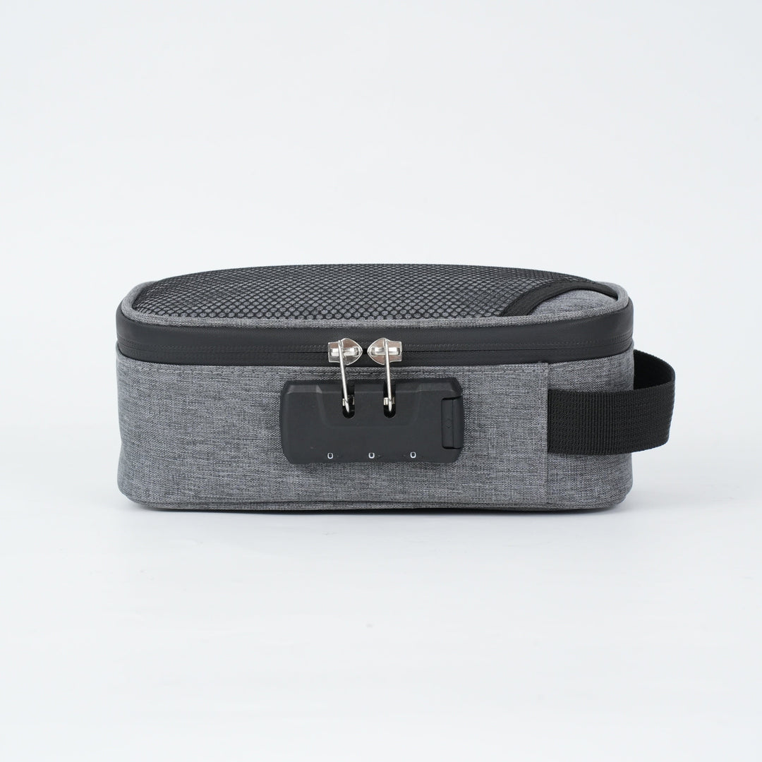 Borsa da viaggio grigia con chiusura a combinazione, maniglia laterale e design compatto. Ideale per organizzare accessori e oggetti personali.