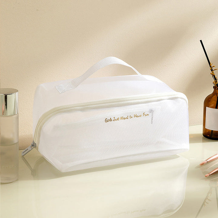 Borsa cosmetica bianca trasparente con cerniera, manico superiore, su tavolo da toeletta. Ideale per organizzare trucchi e accessori da viaggio.