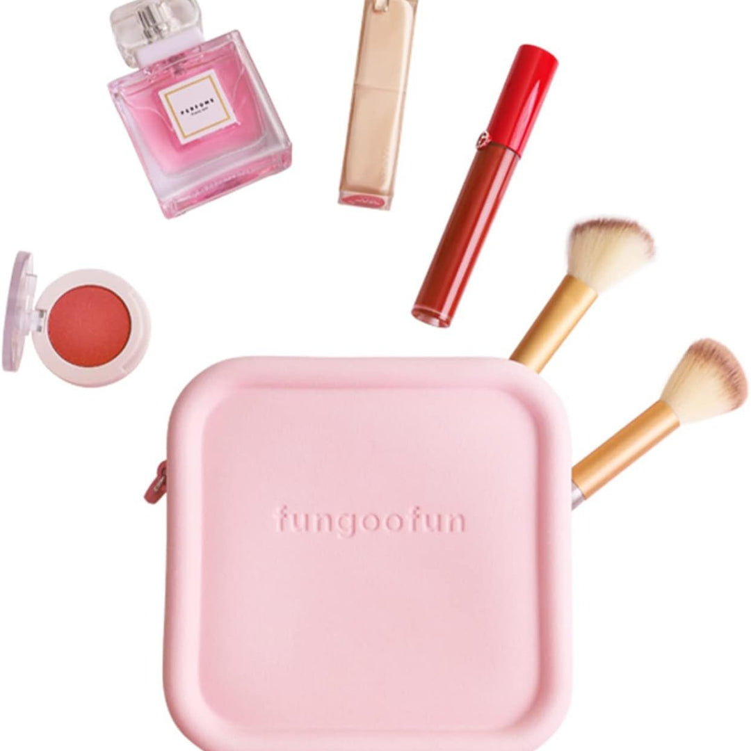 Set di cosmetici con borsa rosa, pennelli trucco, rossetto rosso, ombretto, profumo e lucidalabbra. Accessori bellezza essenziali.