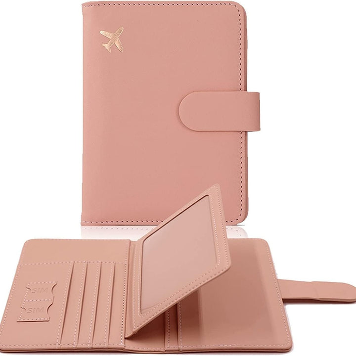 Porta passaporto rosa in pelle con chiusura a bottone, decorato con un piccolo aereo dorato. Include slot per carte e SIM. Accessorio da viaggio elegante.