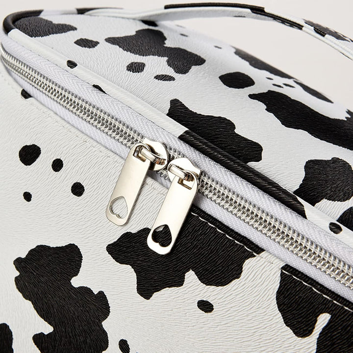 Borsa a tracolla in ecopelle bianca e nera con stampa mucca, chiusura a zip argentata, design moderno, accessorio moda donna.