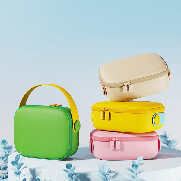 Quattro borse termiche colorate impilate su sfondo blu: verde, gialla, rosa e beige. Design moderno, ideale per picnic e viaggi.