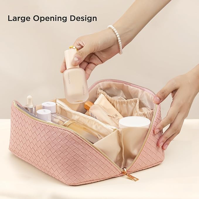 Astuccio cosmetico rosa intrecciato con ampia apertura, contenente flaconi e accessori per trucco. Design elegante, ideale per organizzare prodotti di bellezza.
