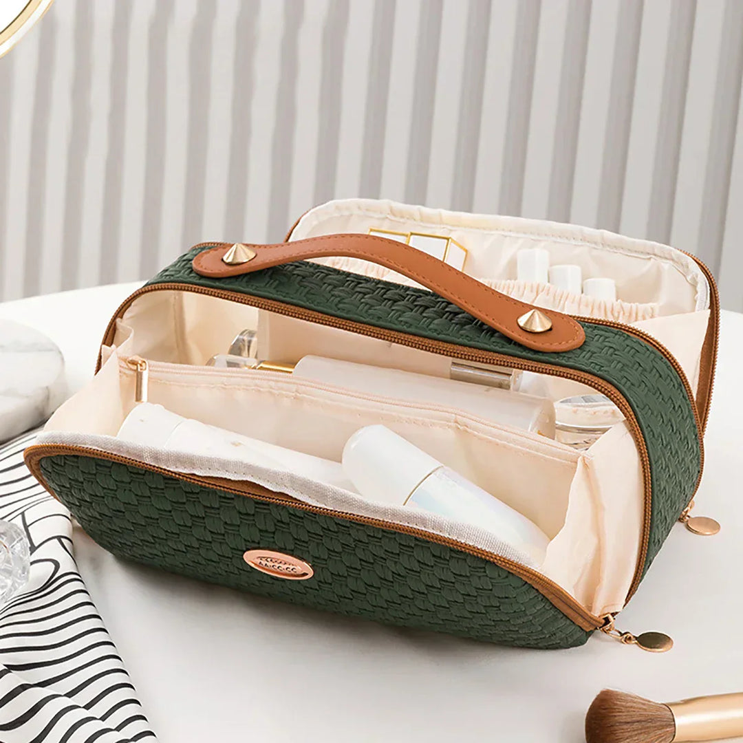 Borsa da toilette verde intrecciata con manico in pelle marrone, scomparti multipli, ideale per organizzare cosmetici e accessori da viaggio.