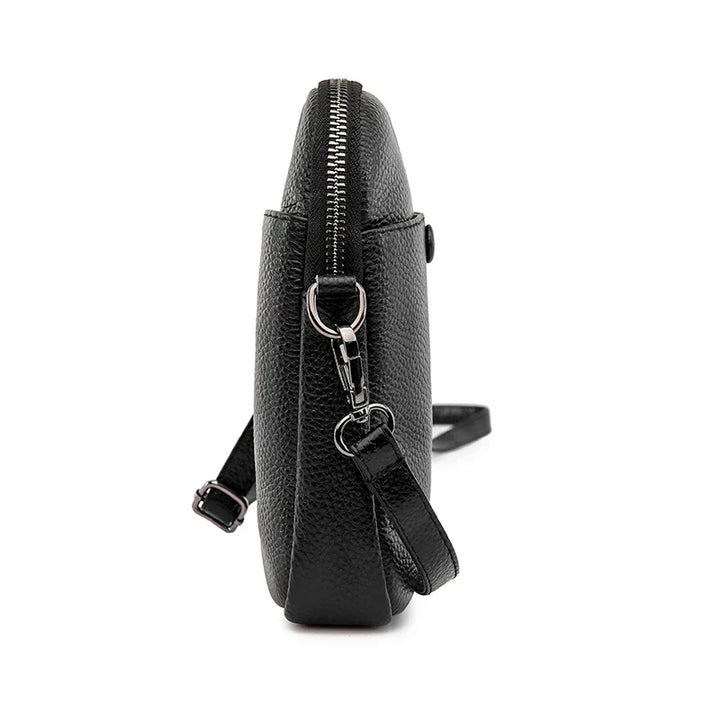 Borsa a tracolla in pelle nera, vista laterale, con cerniera e tracolla regolabile. Design elegante e moderno, ideale per ogni occasione.