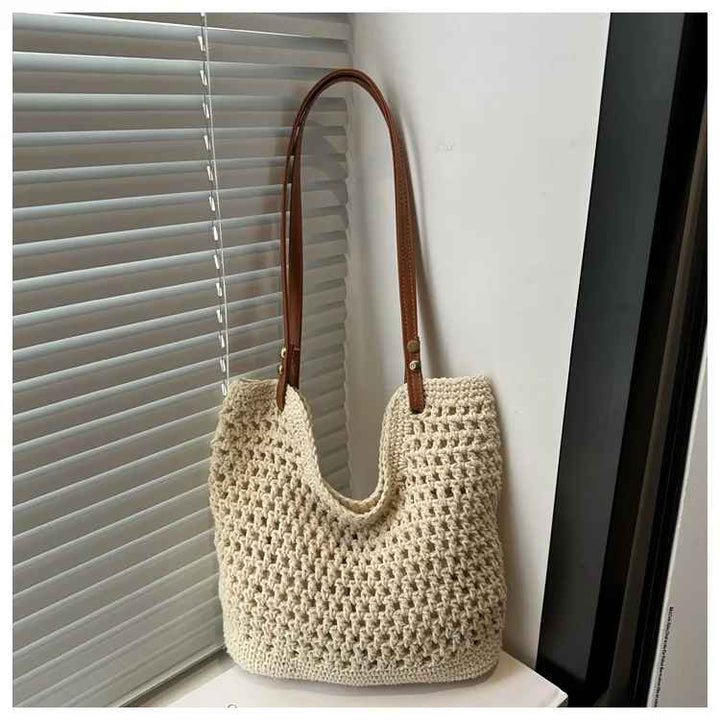 Borsa a spalla in maglia beige con manici in pelle marrone, design elegante e moderno, perfetta per moda donna, accessorio casual chic.