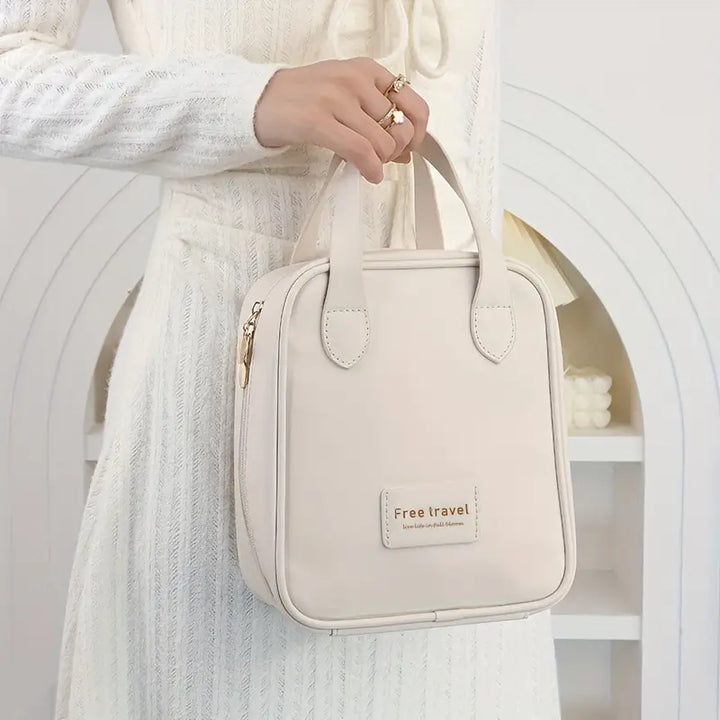 Donna con borsa da viaggio beige, elegante e compatta, in tessuto di alta qualità. Ideale per organizzare accessori e cosmetici.
