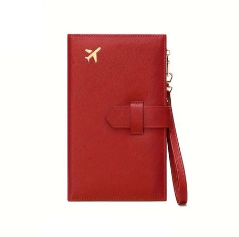 Portafoglio da viaggio rosso in pelle con icona dorata di aereo, cinturino da polso, design elegante e funzionale per passaporti e documenti.