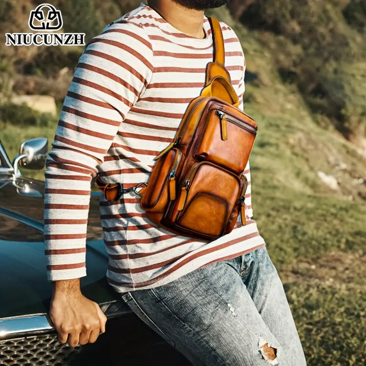 Uomo con borsa a tracolla in pelle marrone, stile casual, appoggiato a un'auto. Moda maschile, accessori eleganti, outdoor.