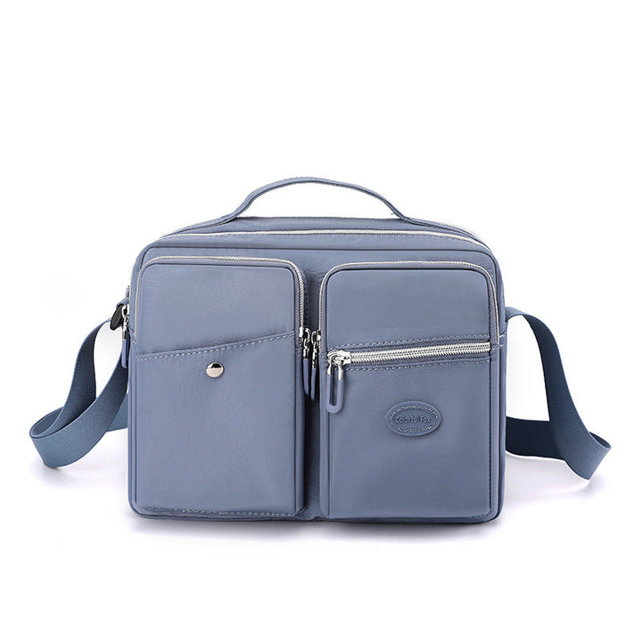Borsa a tracolla in pelle blu con tasche multiple e cerniere, design elegante e funzionale, ideale per uomo e donna, perfetta per uso quotidiano.