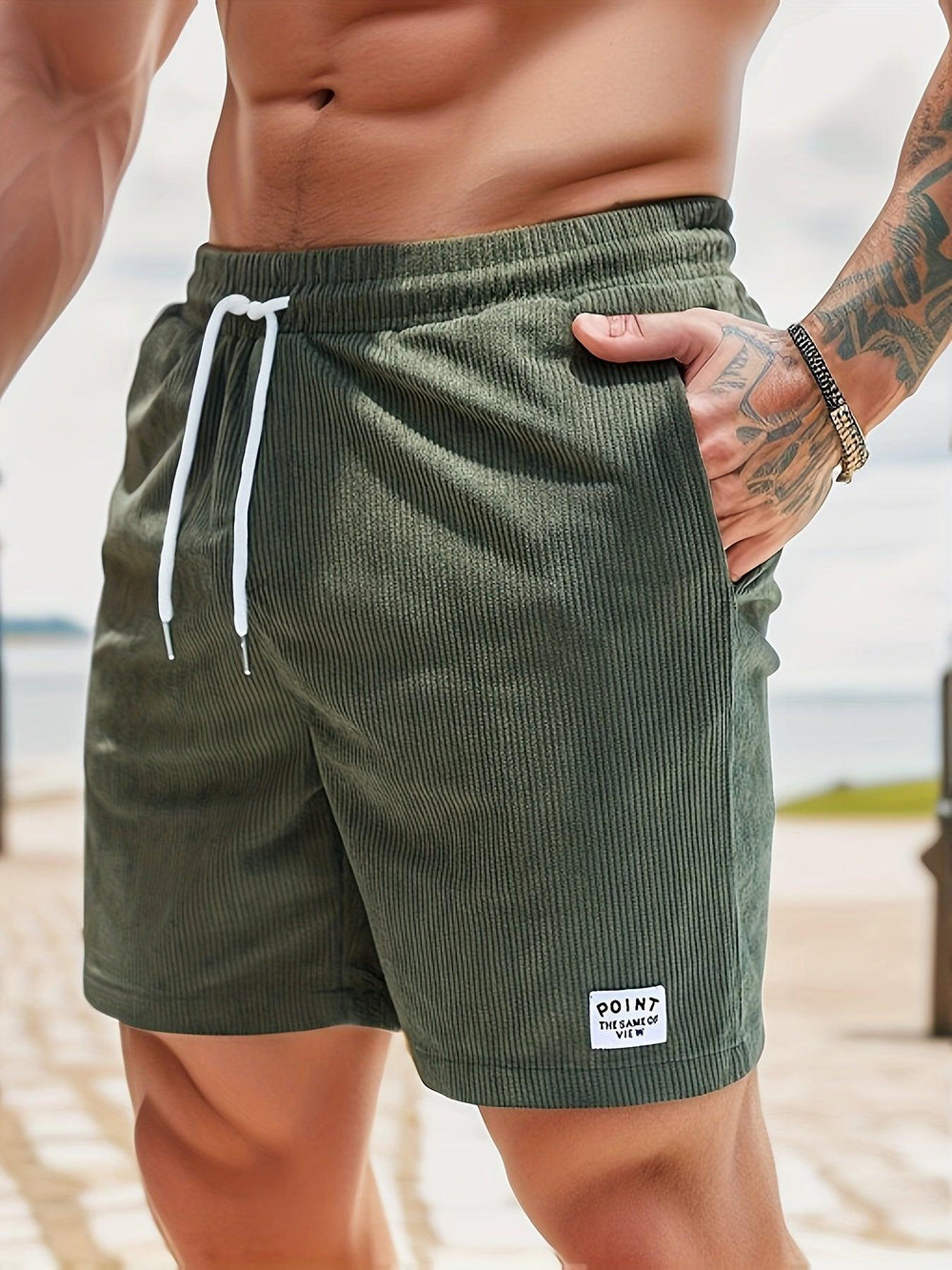 Shorts da uomo verde oliva a coste, con laccio bianco in vita e tasche laterali. Ideali per moda estiva e look casual.