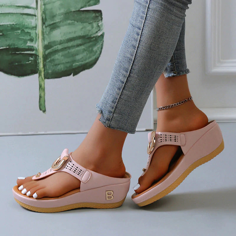 Sandali donna rosa con zeppa, cinturino regolabile, design traforato, indossati con jeans aderenti. Calzature estive moda comode e trendy.