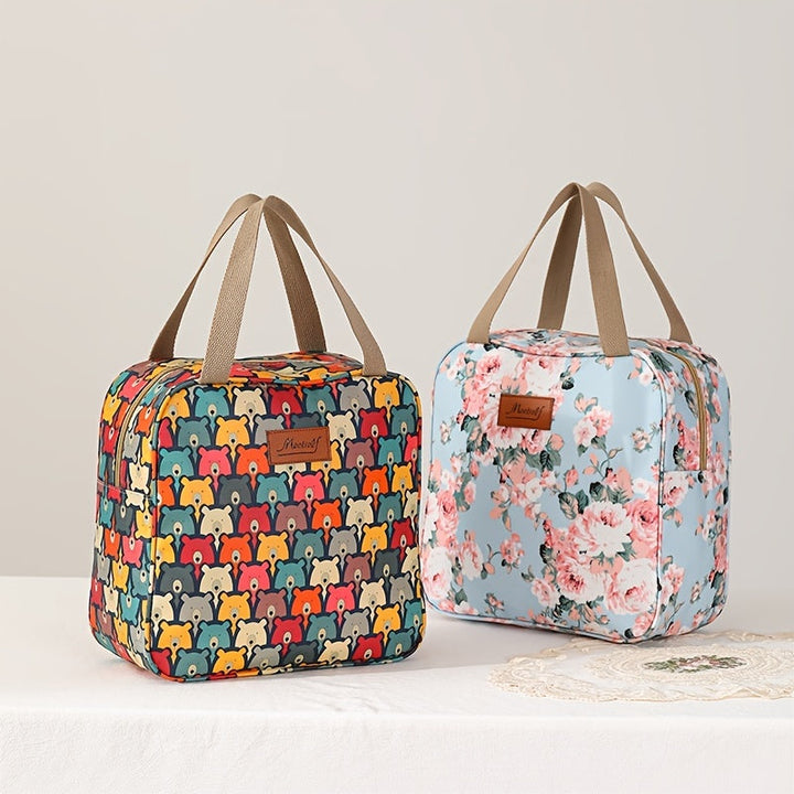Due borse termiche colorate con manici, una con motivo floreale su sfondo azzurro e l'altra con stampa orsetti multicolore, su tavolo bianco.