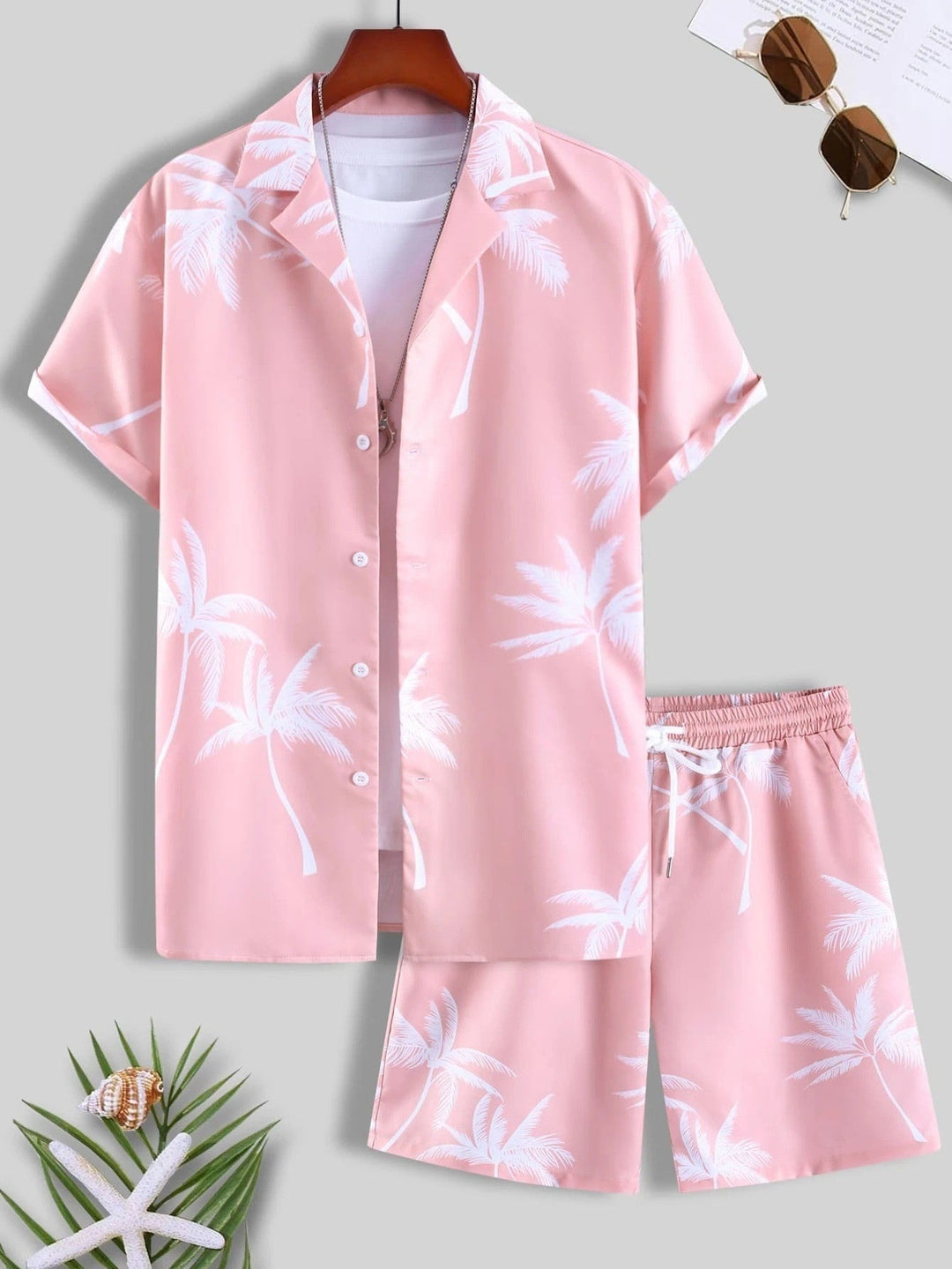Completo estivo uomo rosa con palme bianche, camicia a maniche corte e pantaloncini coordinati. Perfetto per look casual e vacanze.