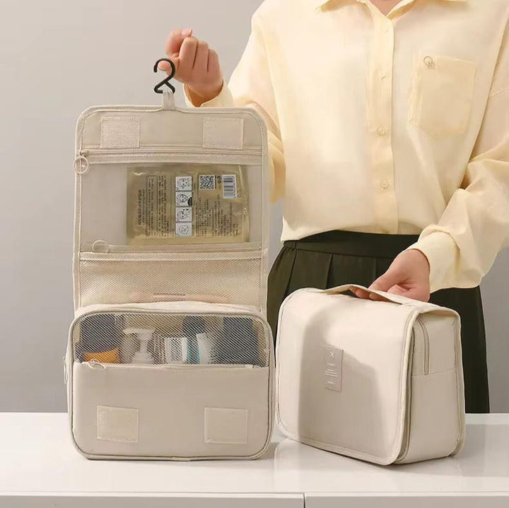 Borsa da toilette beige aperta e chiusa, con gancio, tasche a rete e prodotti da viaggio. Ideale per organizzare cosmetici e accessori.