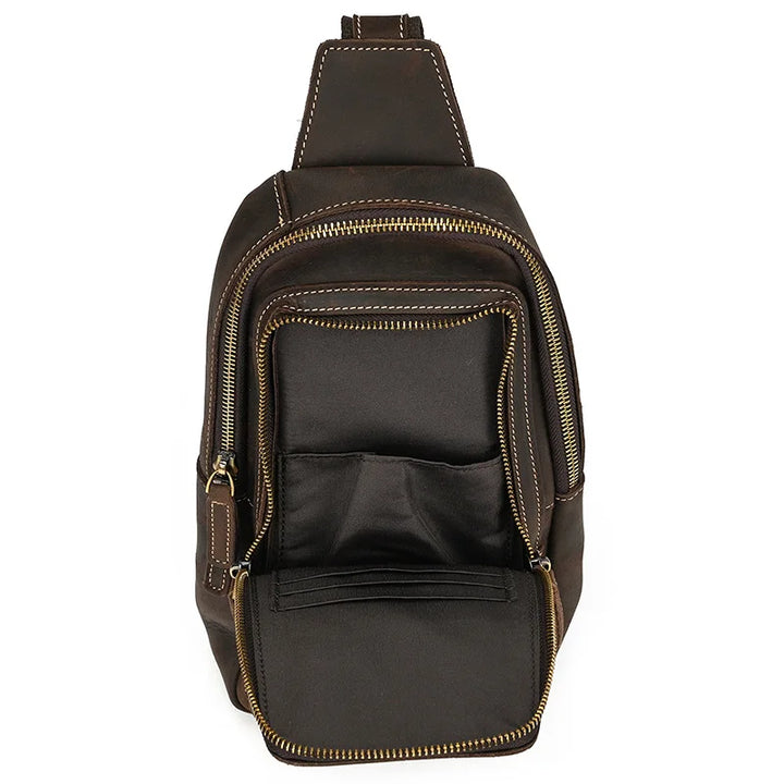 Zaino a tracolla in pelle marrone con cerniere dorate, tasca frontale aperta e cuciture a contrasto. Design elegante e pratico per uomo e donna.