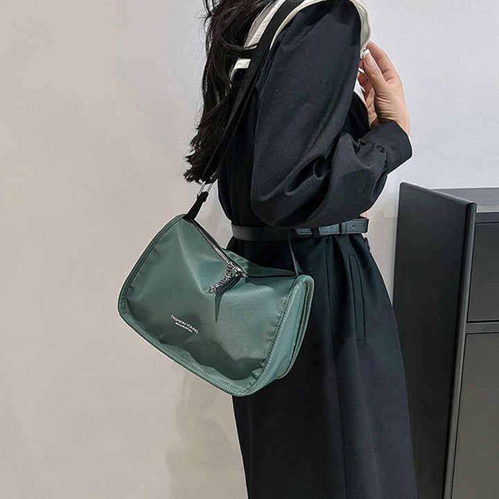 Donna con borsa a tracolla verde, abito nero elegante. Accessorio moda femminile, stile casual chic. Tendenza borse 2023.