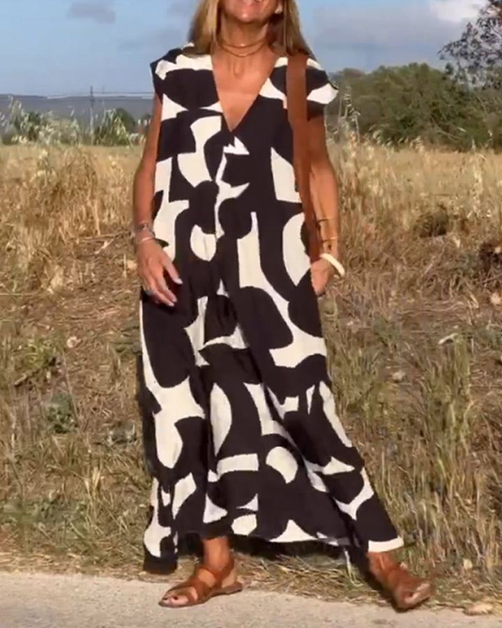 Donna con abito lungo estivo bianco e nero, motivo astratto, in campagna. Moda femminile, abbigliamento casual, stile estivo.