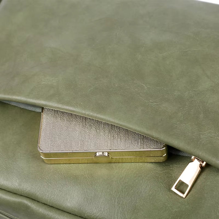 Borsa in pelle verde con chiusura a zip dorata, contenente un portafoglio metallico. Accessorio moda elegante e funzionale per donna.