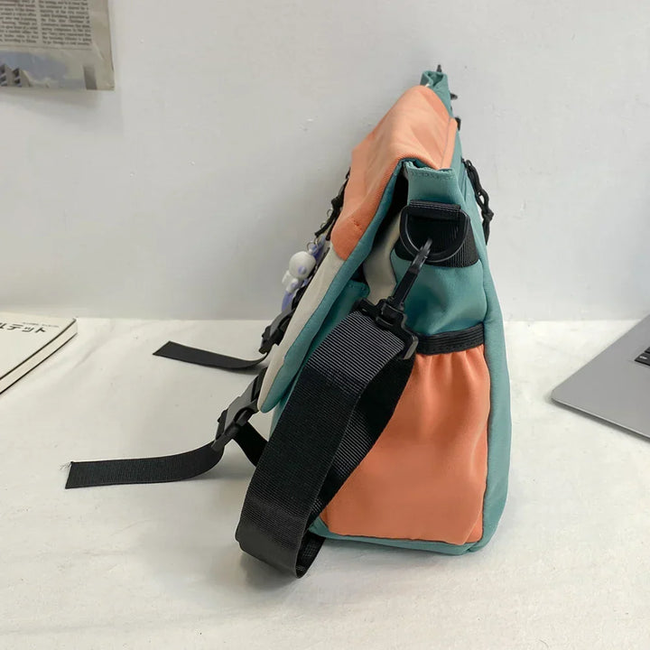 Borsa a tracolla multicolore in tessuto, design moderno con tasche laterali e cinghie regolabili, ideale per uso quotidiano e viaggi.