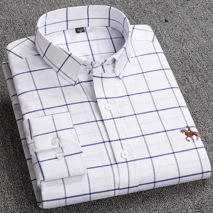 Camicia uomo bianca a quadri blu, manica lunga, colletto classico, ricamo cavallo, tessuto cotone, elegante e casual, piegata su sfondo grigio.