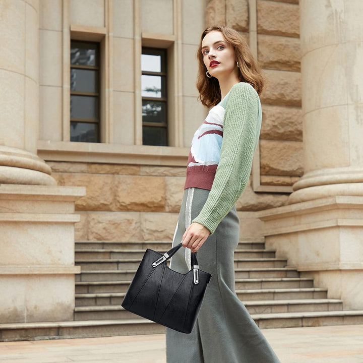 Donna elegante con borsa a mano nera in pelle, abbigliamento autunnale, sfondo architettonico classico. Moda femminile, accessori di lusso.