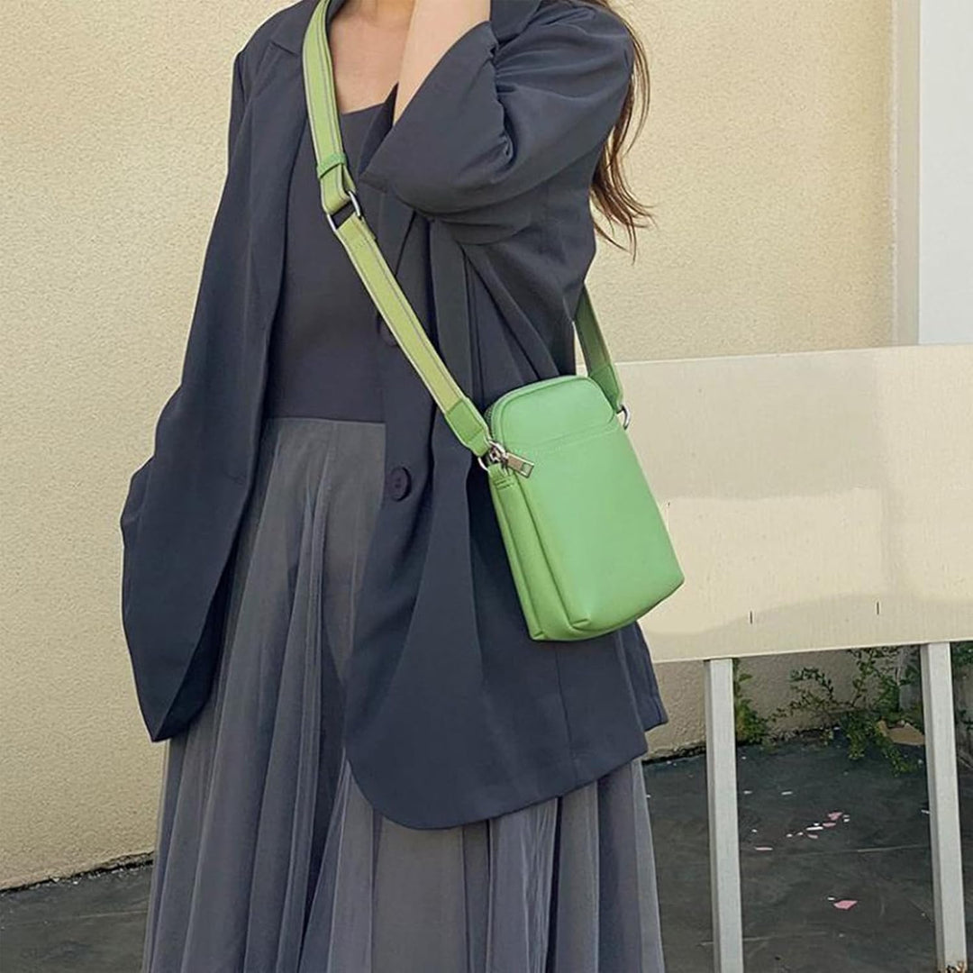 Donna con borsa a tracolla verde, indossa giacca e gonna grigia. Moda femminile elegante, accessori trendy, abbigliamento casual chic.