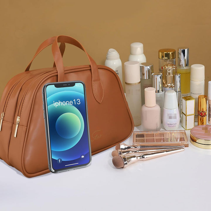 Borsa cosmetica marrone con iPhone 13, prodotti di bellezza e pennelli trucco su sfondo beige. Accessori moda e tecnologia.
