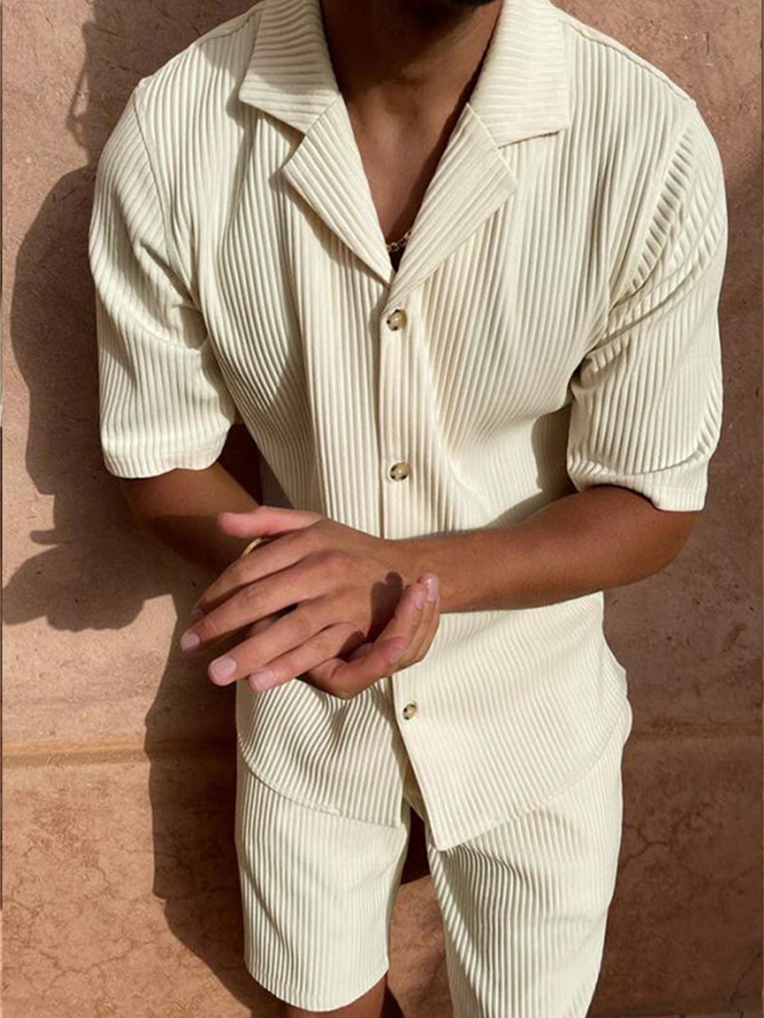 Camicia e pantaloncini a righe crema da uomo, stile casual estivo, maniche corte, sfondo beige, moda maschile, abbigliamento leggero.