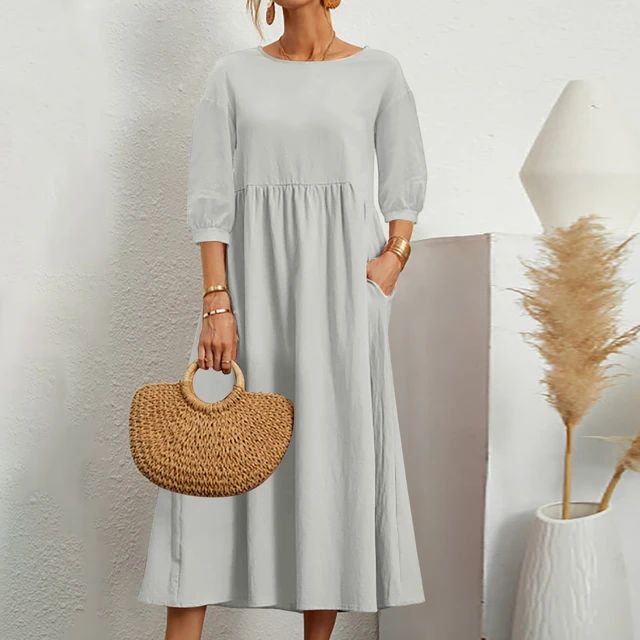 Abito lungo donna grigio chiaro, maniche a tre quarti, tasche laterali, borsa paglia intrecciata, stile casual elegante, moda estiva.