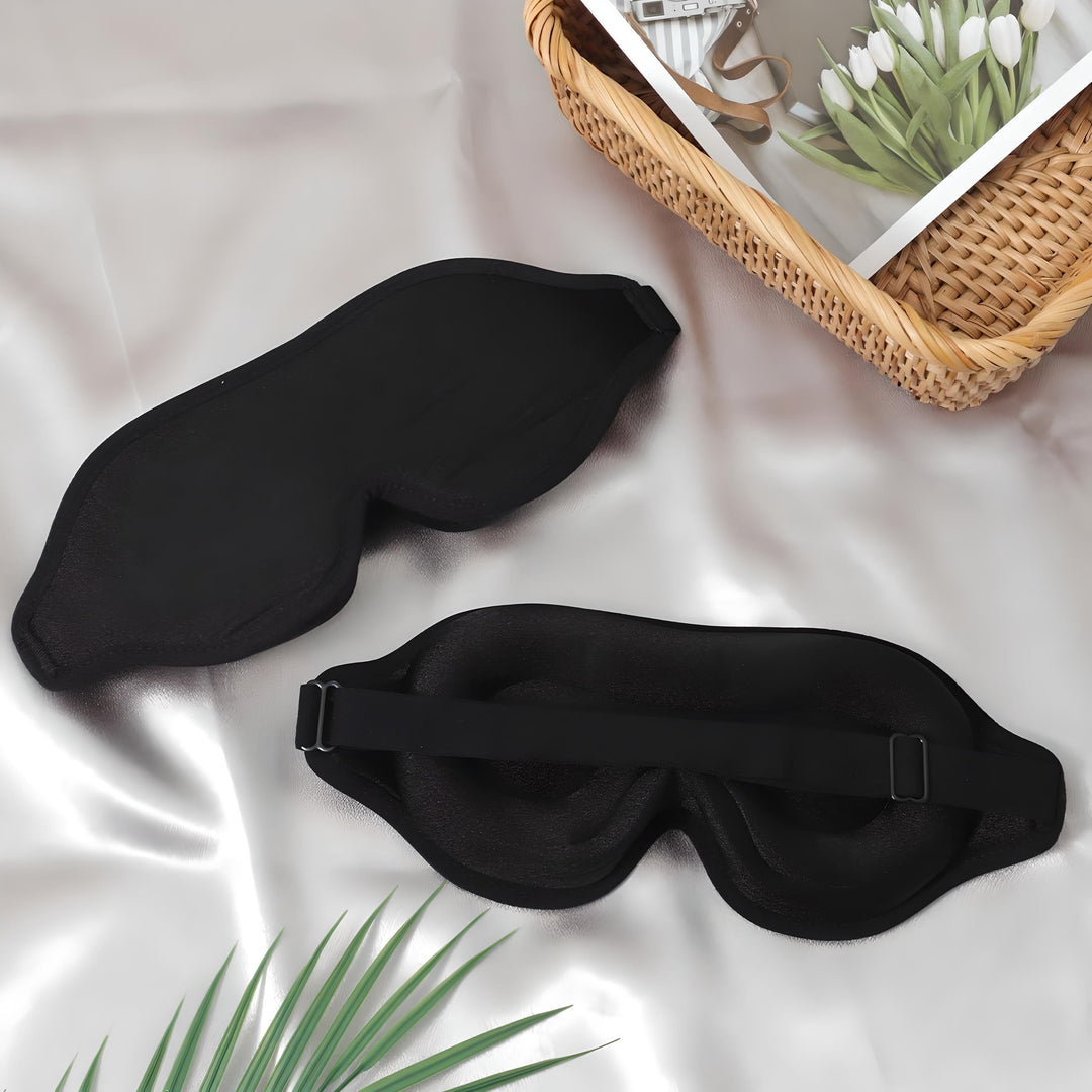 Maschere per dormire nere su tessuto bianco, con cesto di vimini e fiori. Accessori per il sonno, relax, viaggio. Design elegante e confortevole.